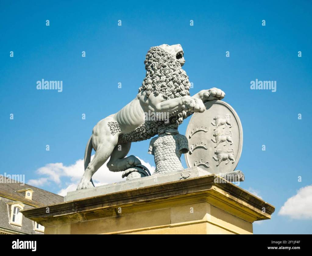 A stone lion statue standing proudly on a pedestal against a clear blue sky.